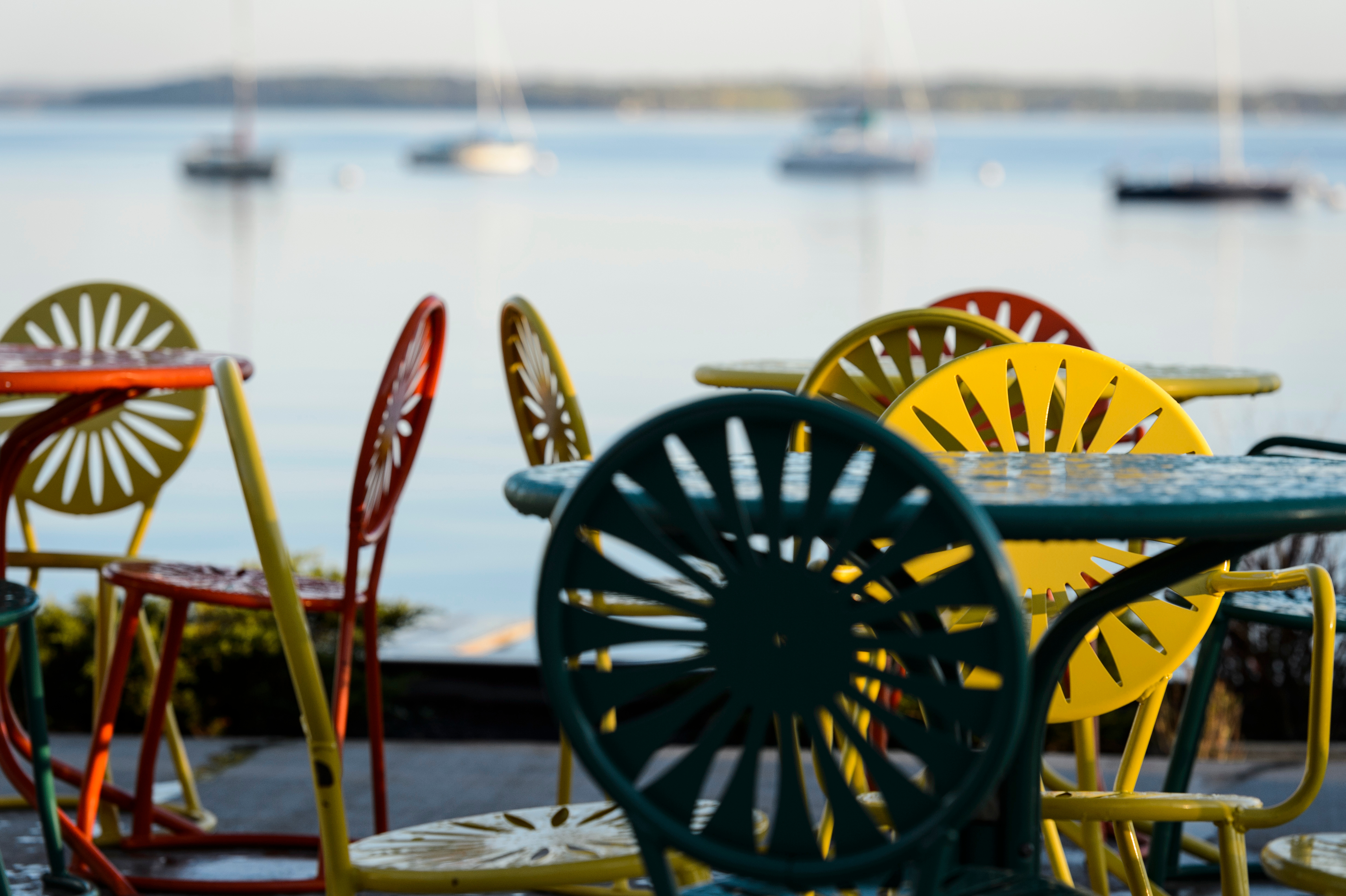 Morning dew covers Memorial Union Terrace chairs and tables at the University of Wisconsin-Madison as Lake Mendota provides a calm background during an autumn sunrise
