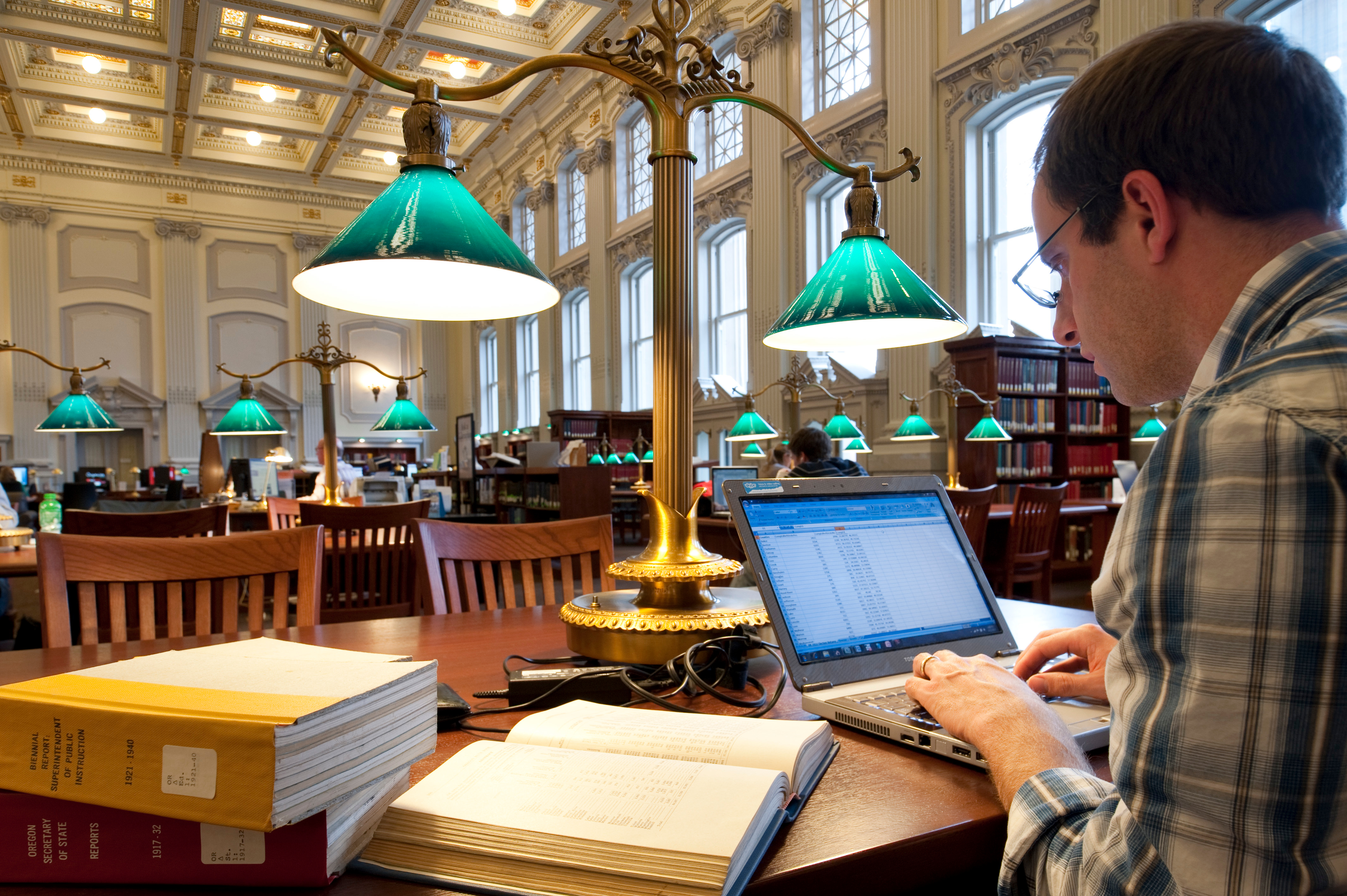 A student studying using his laptop computer in Wisconsin Historical Society library reading room