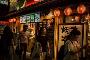 Photo of people walking along a city sidewalk in Japan