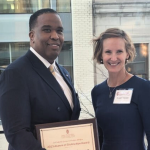 Wes Sparkman holding his Alumni of Distinction Award and standing next to Susan Yackee.