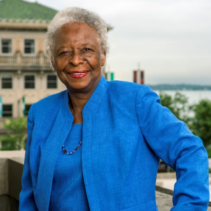 Phot of a woman in a blue blazer standing in front of a building